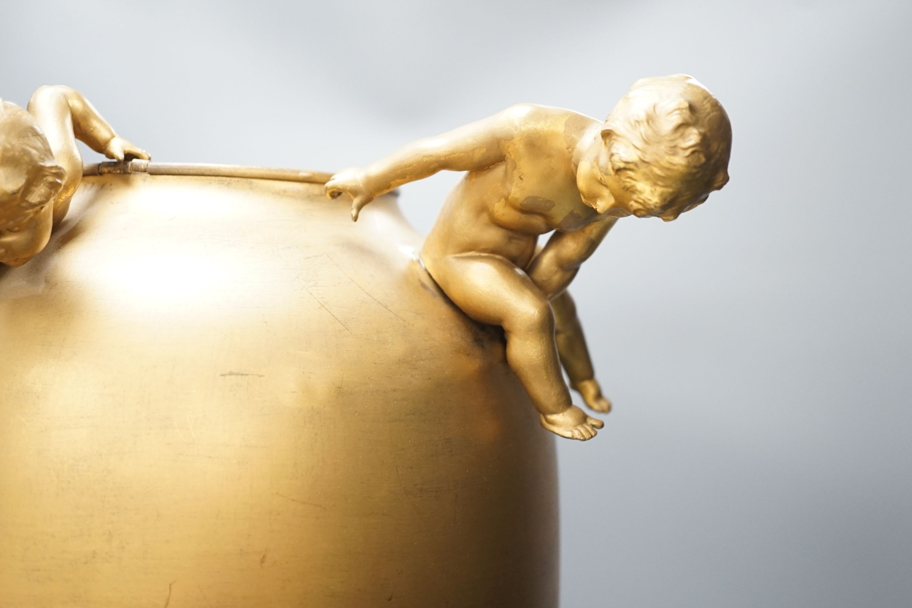 A large Kayser gilt metal ovoid jar, with playful cherubs, 55cm.